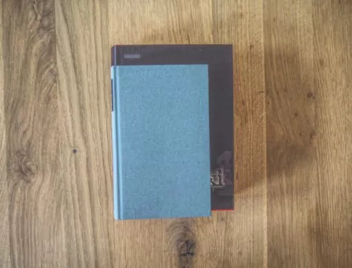 Ein blaues Buch, das auf einem Holztisch liegt.