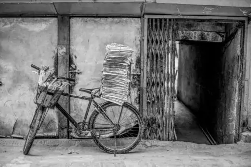 Ein Schwarz-Weiß-Foto eines Fahrrads mit Zeitungen darauf.