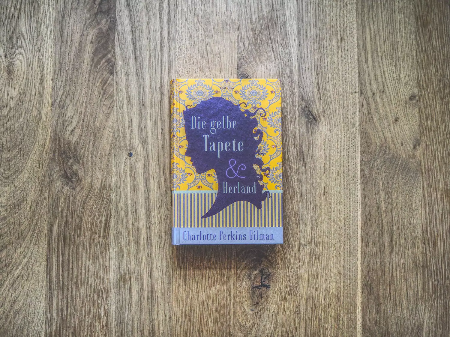 Ein Buch mit violettem Einband auf einem Holzboden.