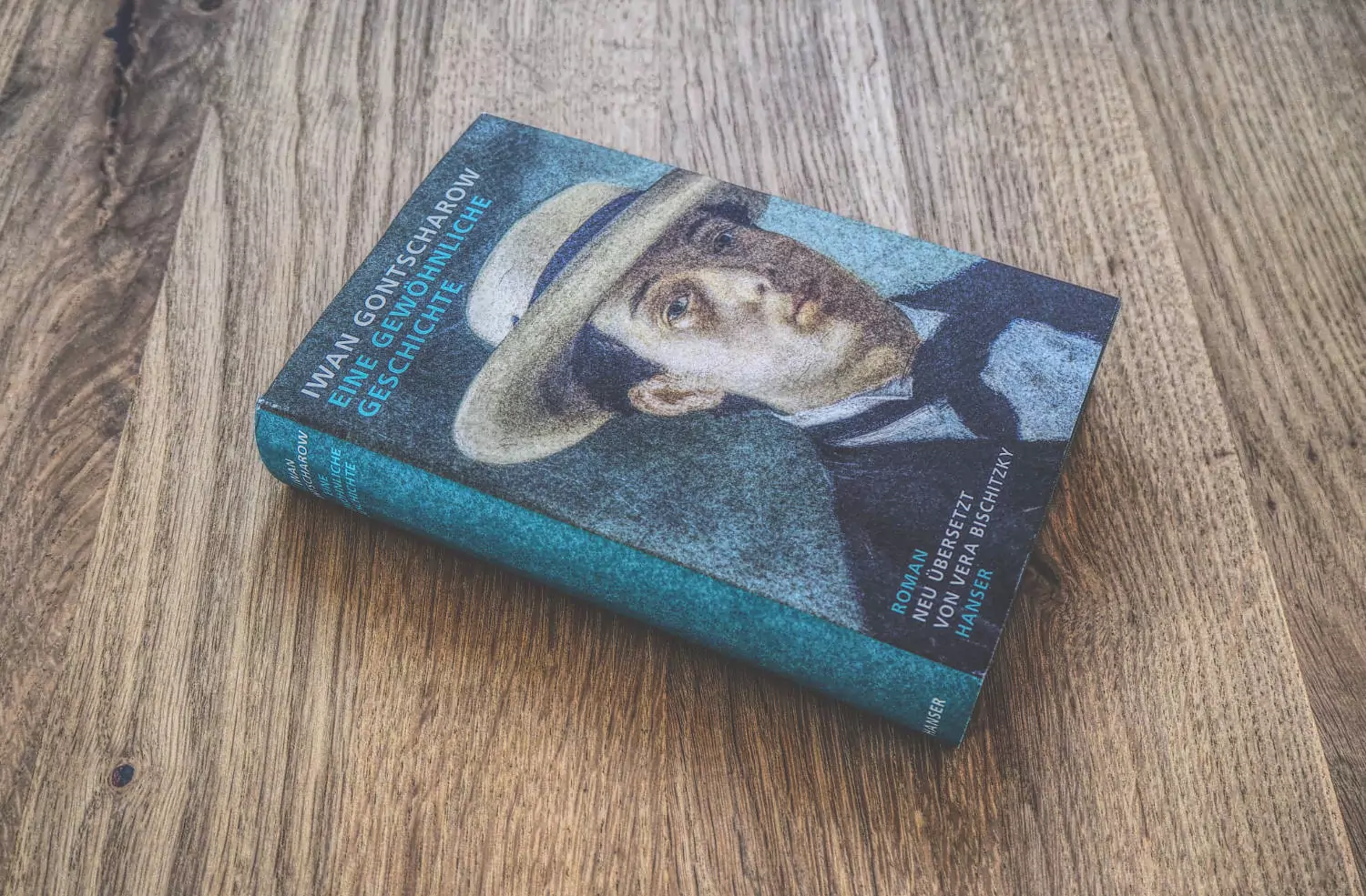 Ein Buch mit dem Bild eines Mannes mit Hut, der auf einem Holztisch sitzt.