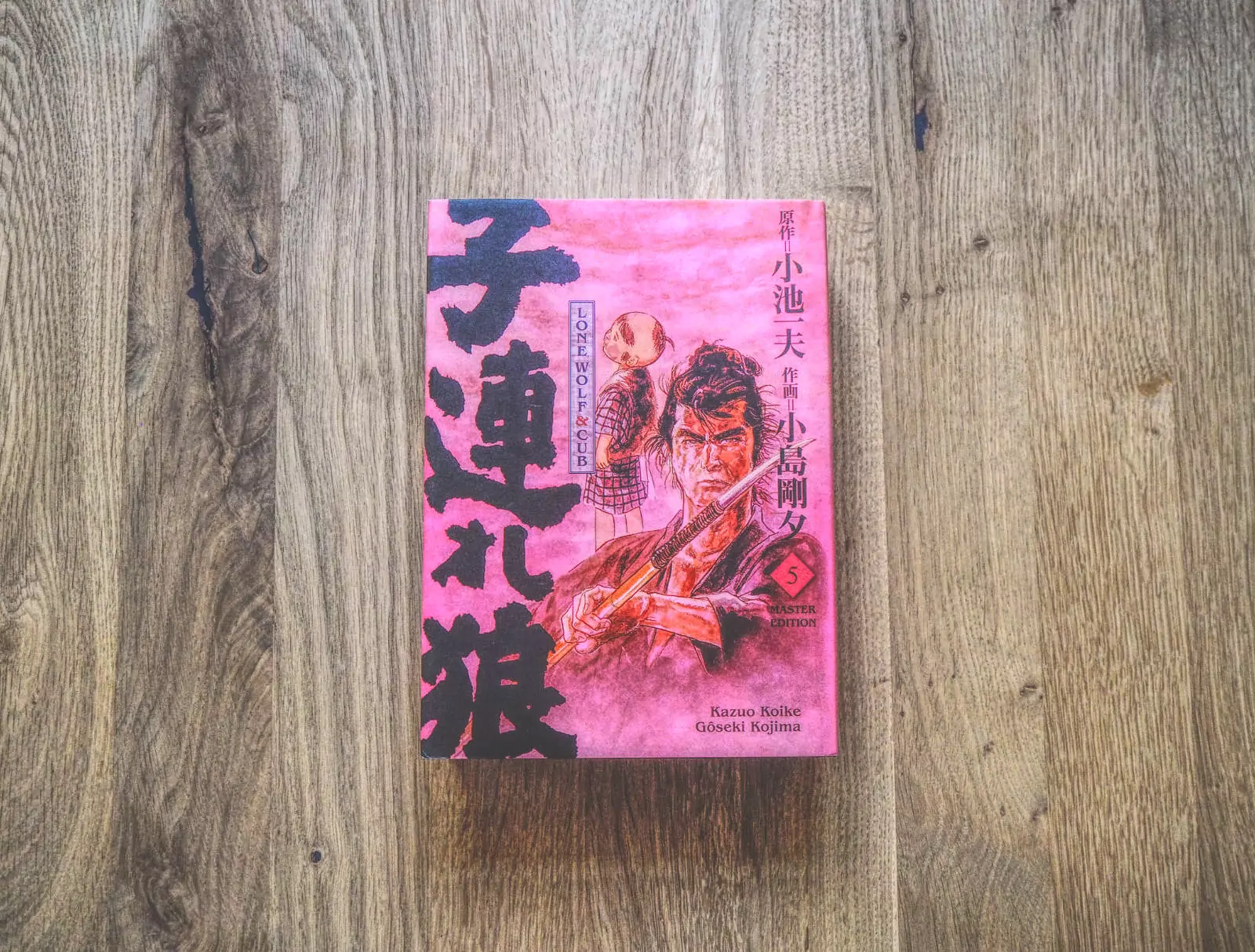 Ein japanisches Buch mit rosa Einband auf einem Holzboden.