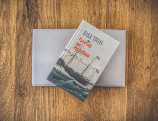 Ein Buch auf einem Holztisch mit einem Schiff darauf.