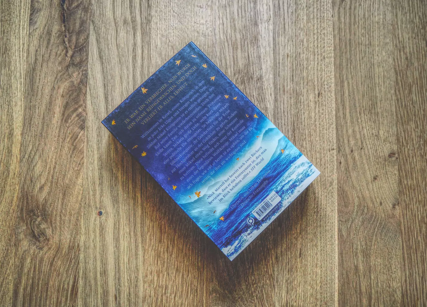 Ein Buch auf einem Holztisch mit blauem Einband.