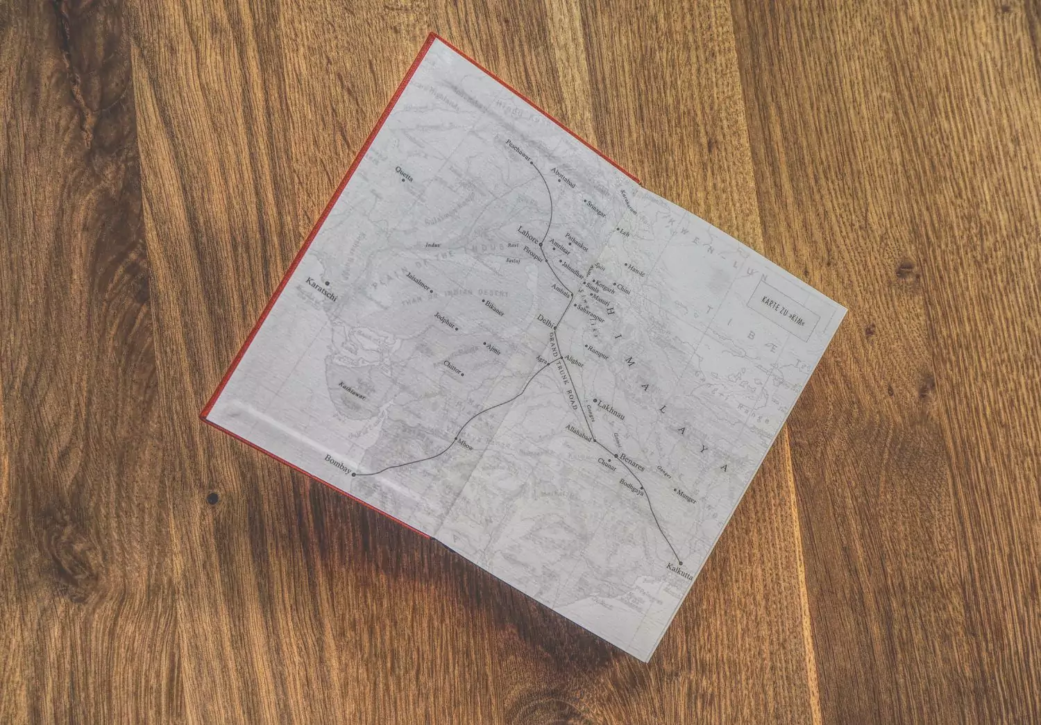 Ein Buch mit einer Karte darauf auf einem Holzboden.