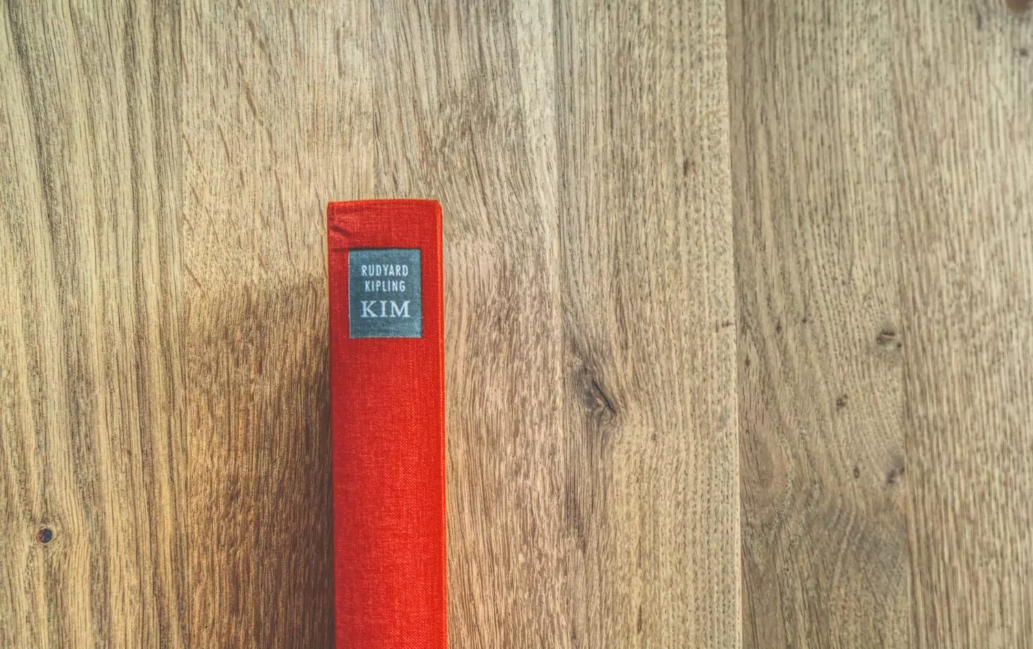 Ein rotes Buch auf einem Holztisch.