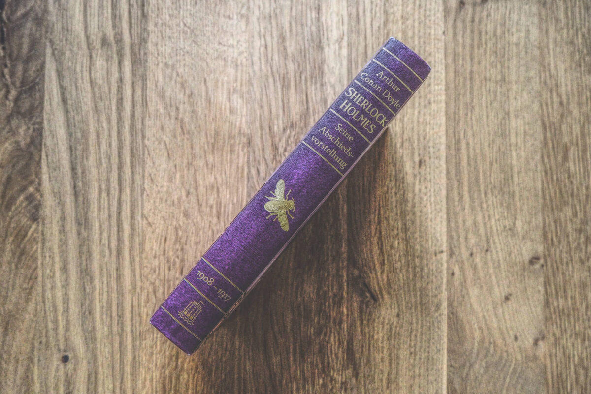 Ein lila Buch auf einem Holztisch.