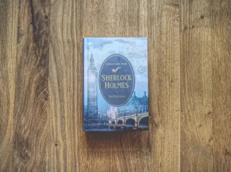 Sherlock Holmes-Buch auf einem Holztisch.
