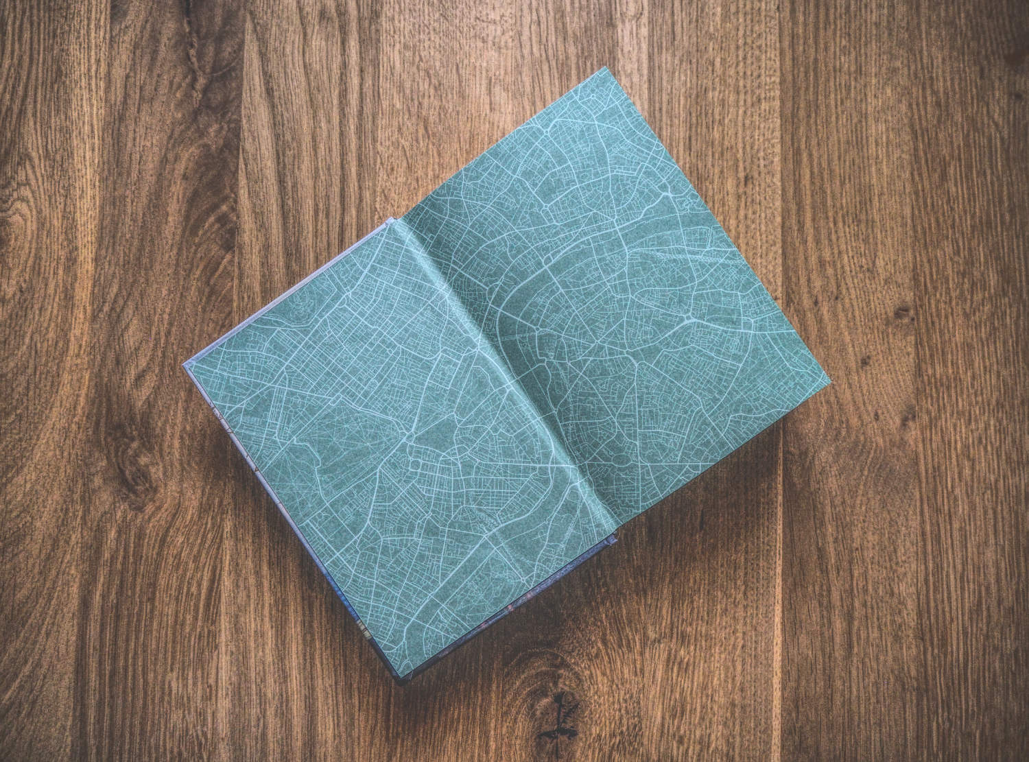 Ein grünes Notizbuch auf einem Holztisch.