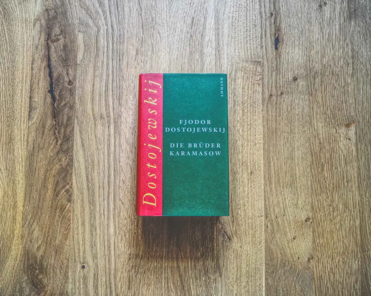 Eine deutsche Ausgabe von Fjodor Dostojewskis "Die Brüder Karamasow" liegt auf einer Holzfläche.