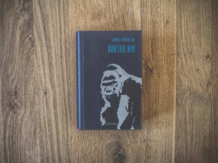 Cover von „Doktor Ain“ von James Tiptree Jr., das einen stilisierten Gorilla auf einer Holzoberfläche zeigt.