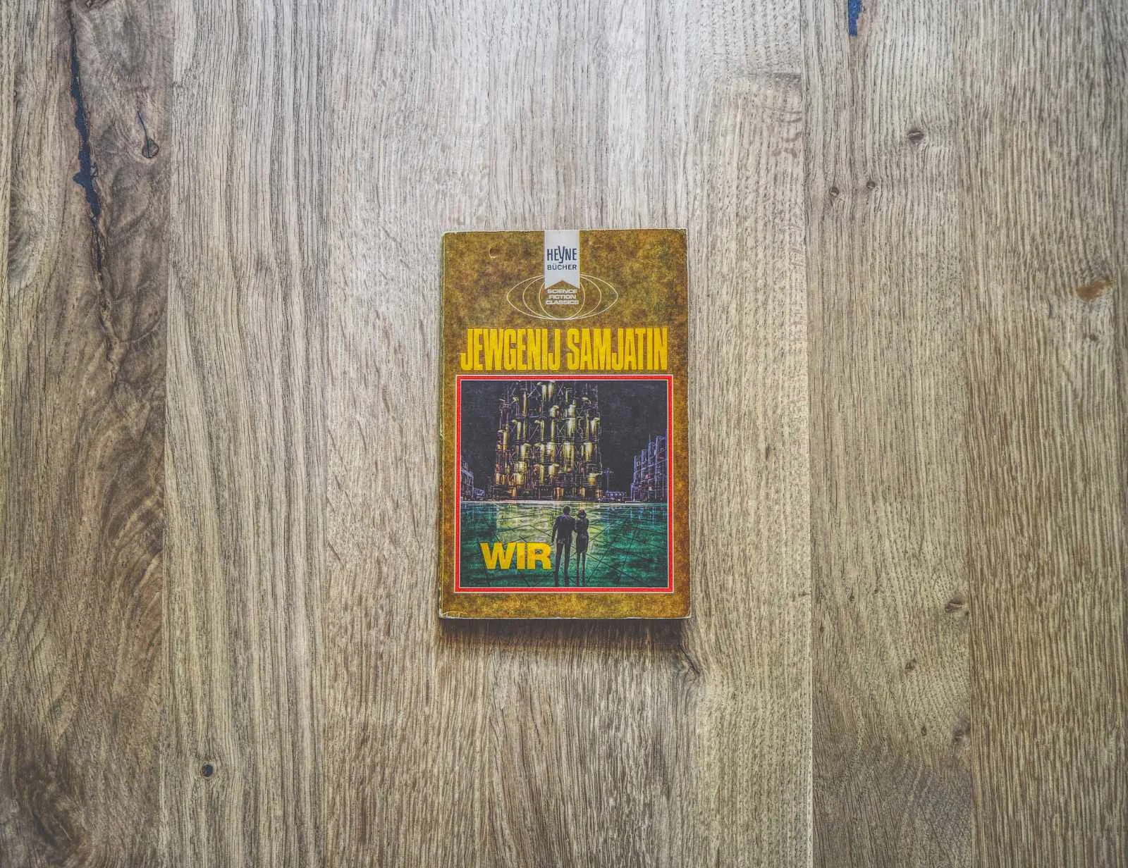 Ein Exemplar des Buches "Wir" von Jewgenij Samjatin liegt auf einer Holzfläche.