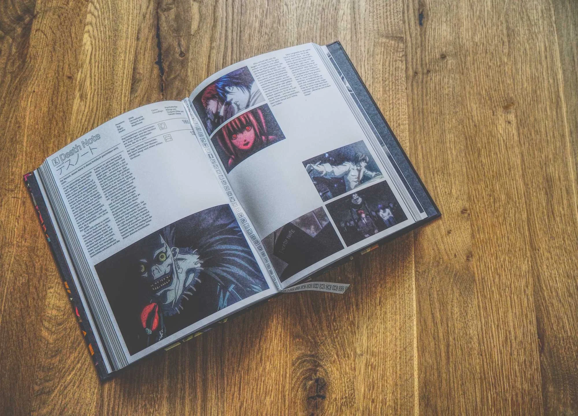Ein aufgeschlagenes Buch auf einer hölzernen Oberfläche zeigt Texte und Bilder aus dem Manga "Death Note", die verschiedene Figuren und Szenen zeigen.