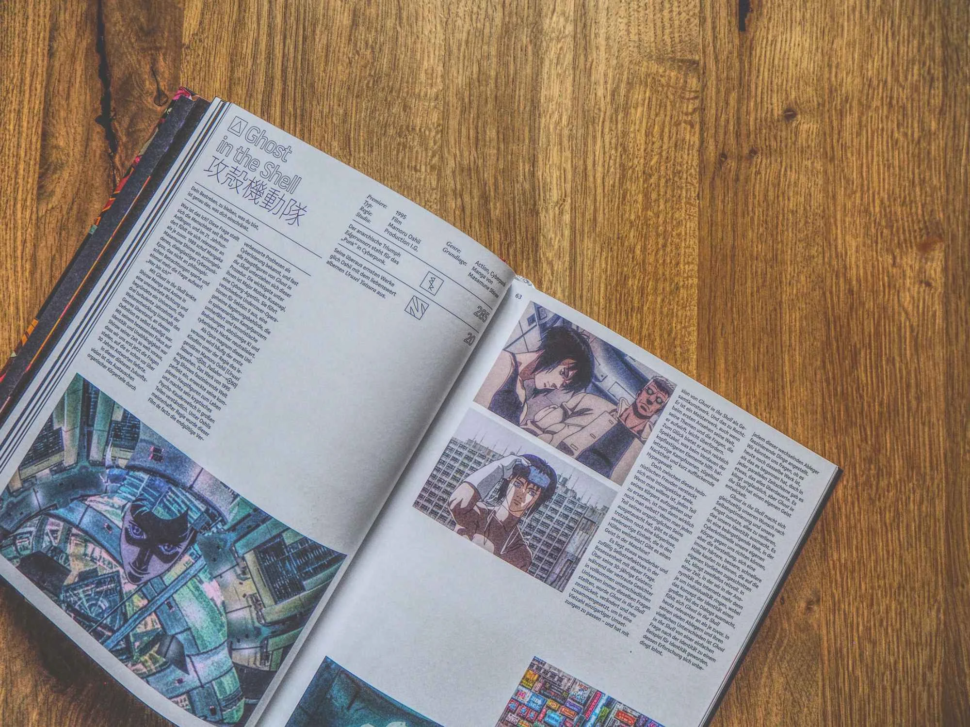 Ein aufgeschlagenes Magazin auf einem Holztisch zeigt Seiten mit Text und mehreren Bildern aus einem Animationsfilm oder einer Serie.