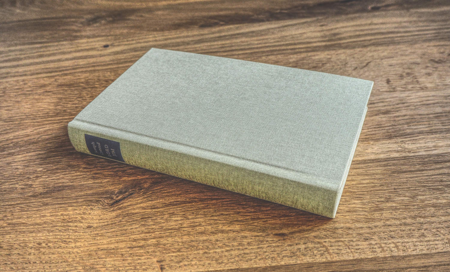 Ein weißes Buch auf einem Holztisch.