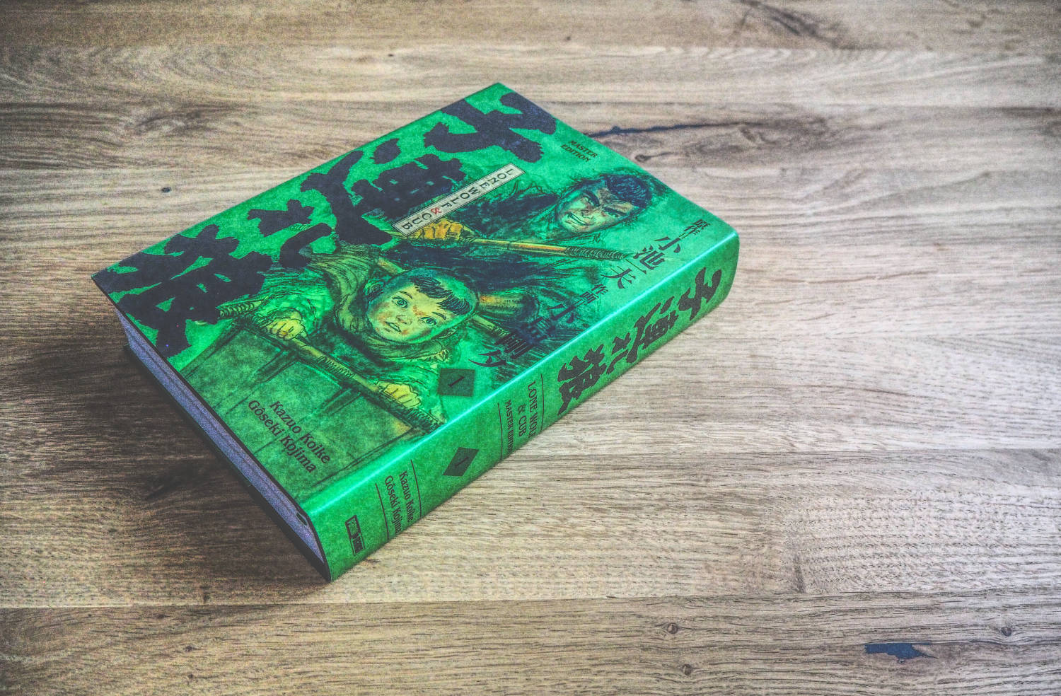 Ein grünes Buch auf einem Holztisch.
