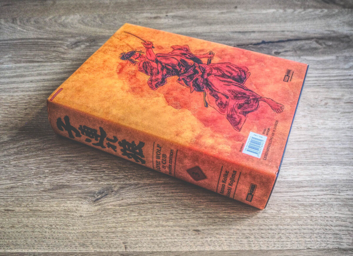 Ein Buch mit einem Bild eines Samurai, der auf einem Holztisch sitzt.