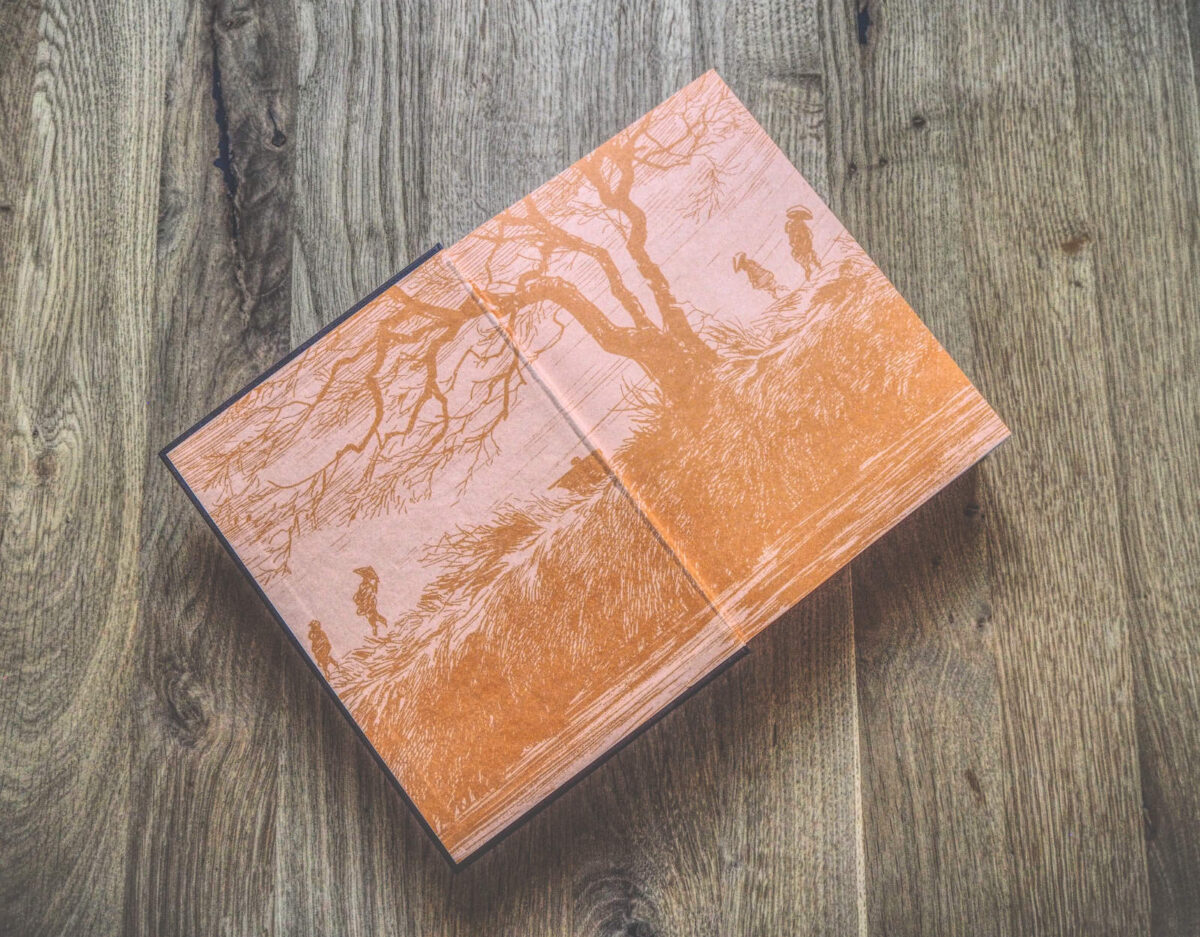 Ein Buch mit orangefarbenem Einband auf einem Holzboden.