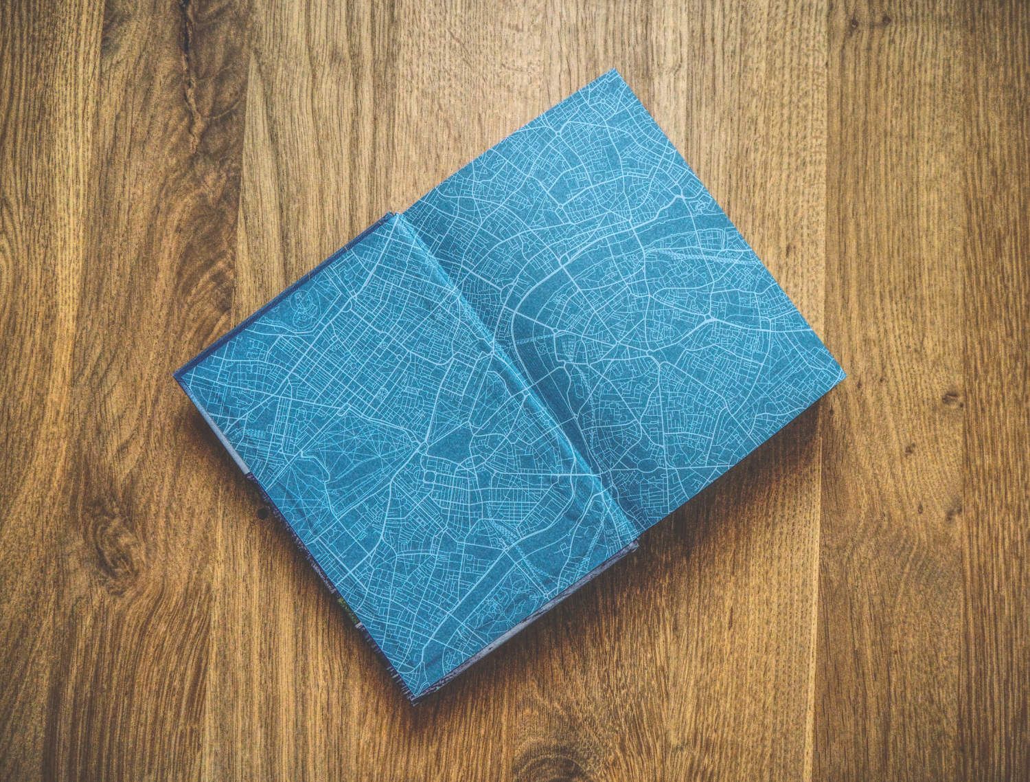 Ein blaues Notizbuch auf einem Holztisch.