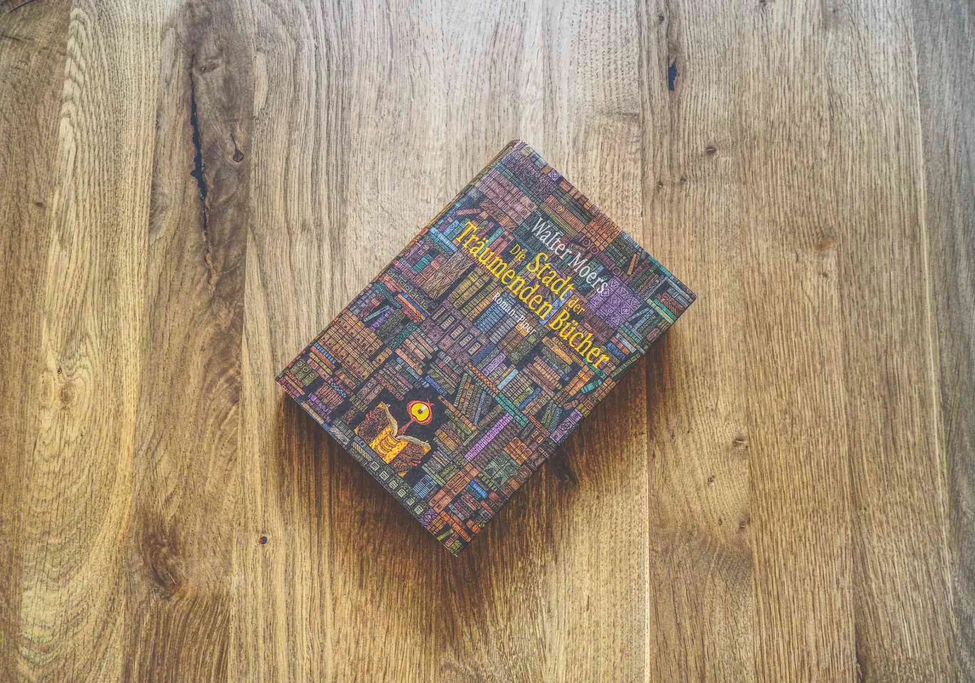 Ein gebundenes Buch mit dem Titel "Die Stadt der Träumenden Bücher" liegt auf einer Holzfläche.